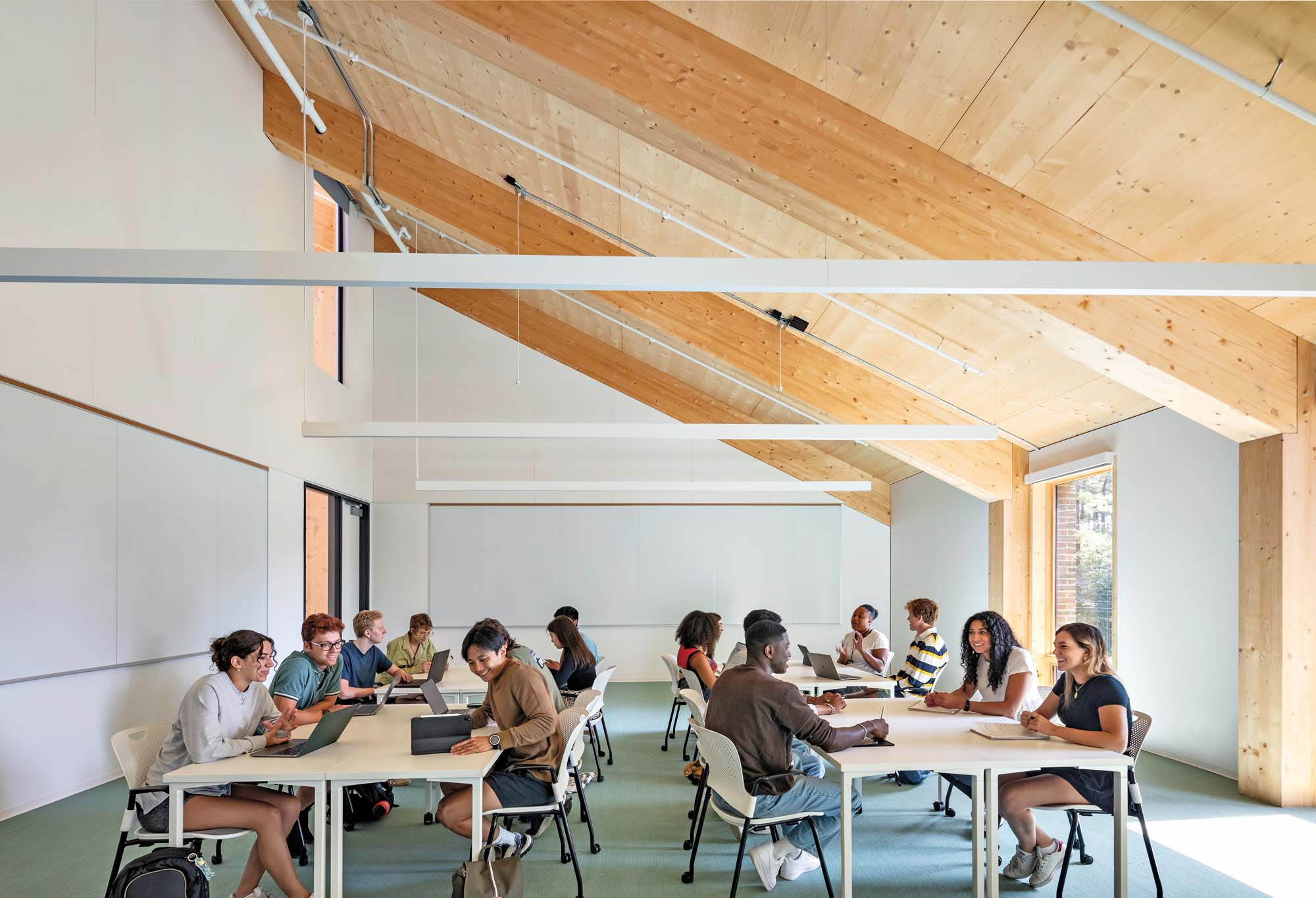 Students working at large tables in campus building