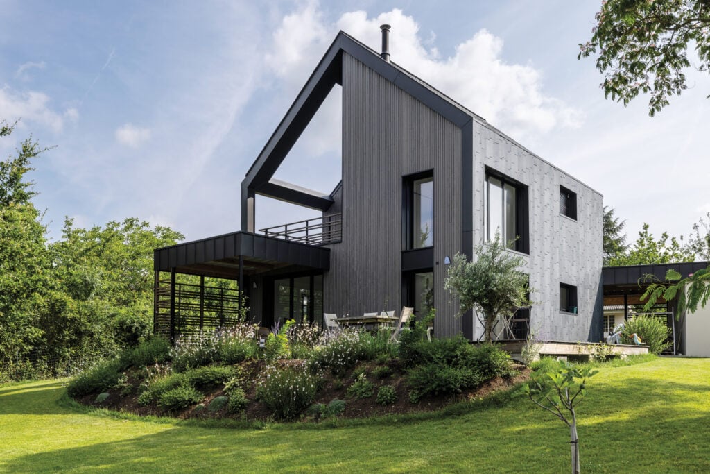 image of a house sitting on a green lawn with blue sky
