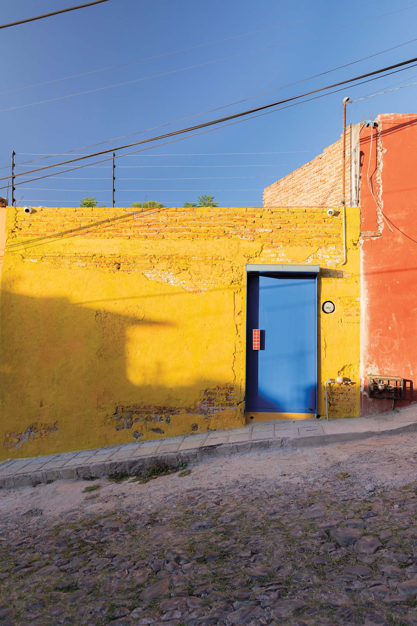 mustard brick wall with a blue door
