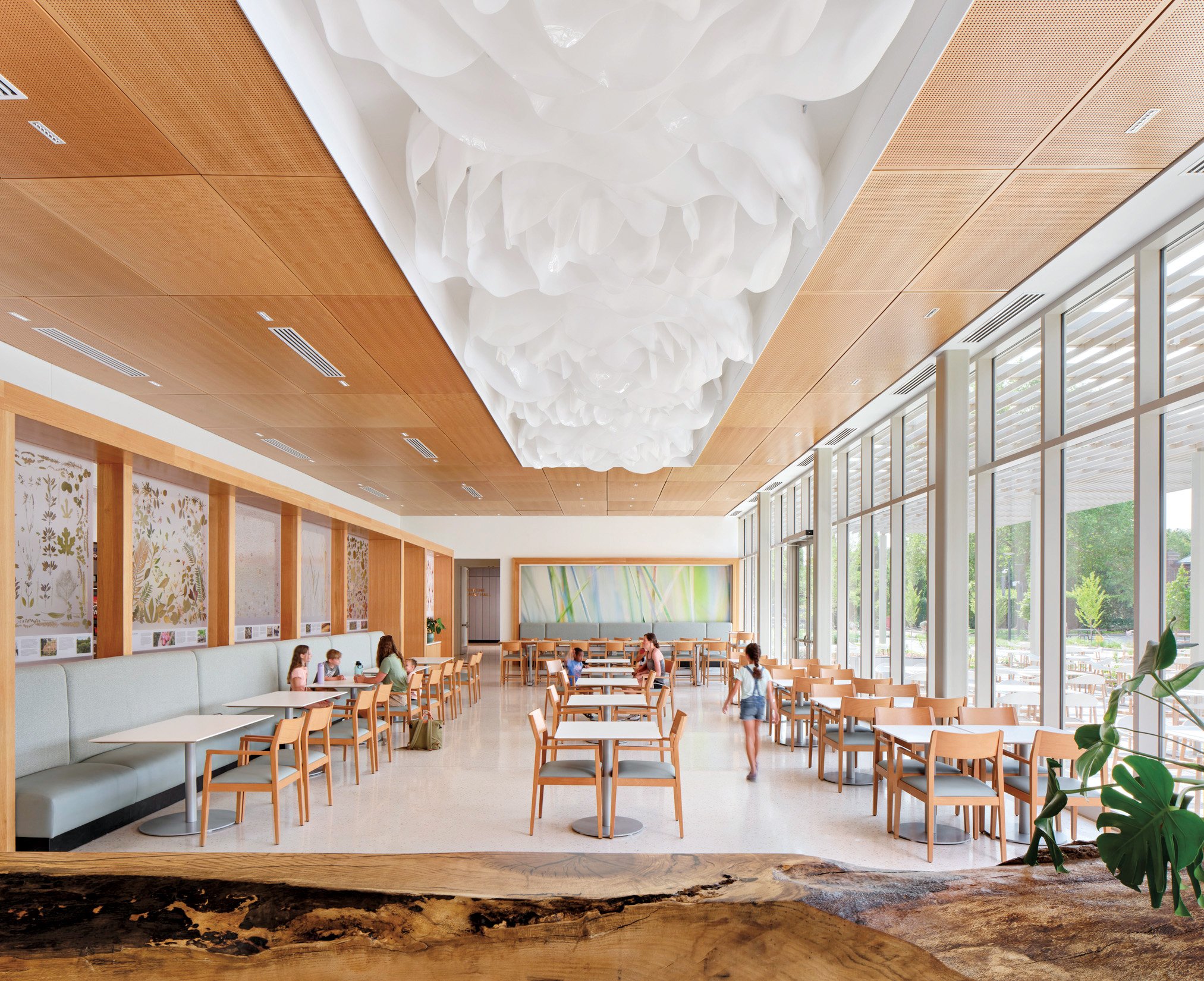 an image of a light-filled room with people sitting down at cafe tables